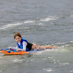 Child smiling on a Wild Thing orange kneeboard with handles, wearing a life vest.