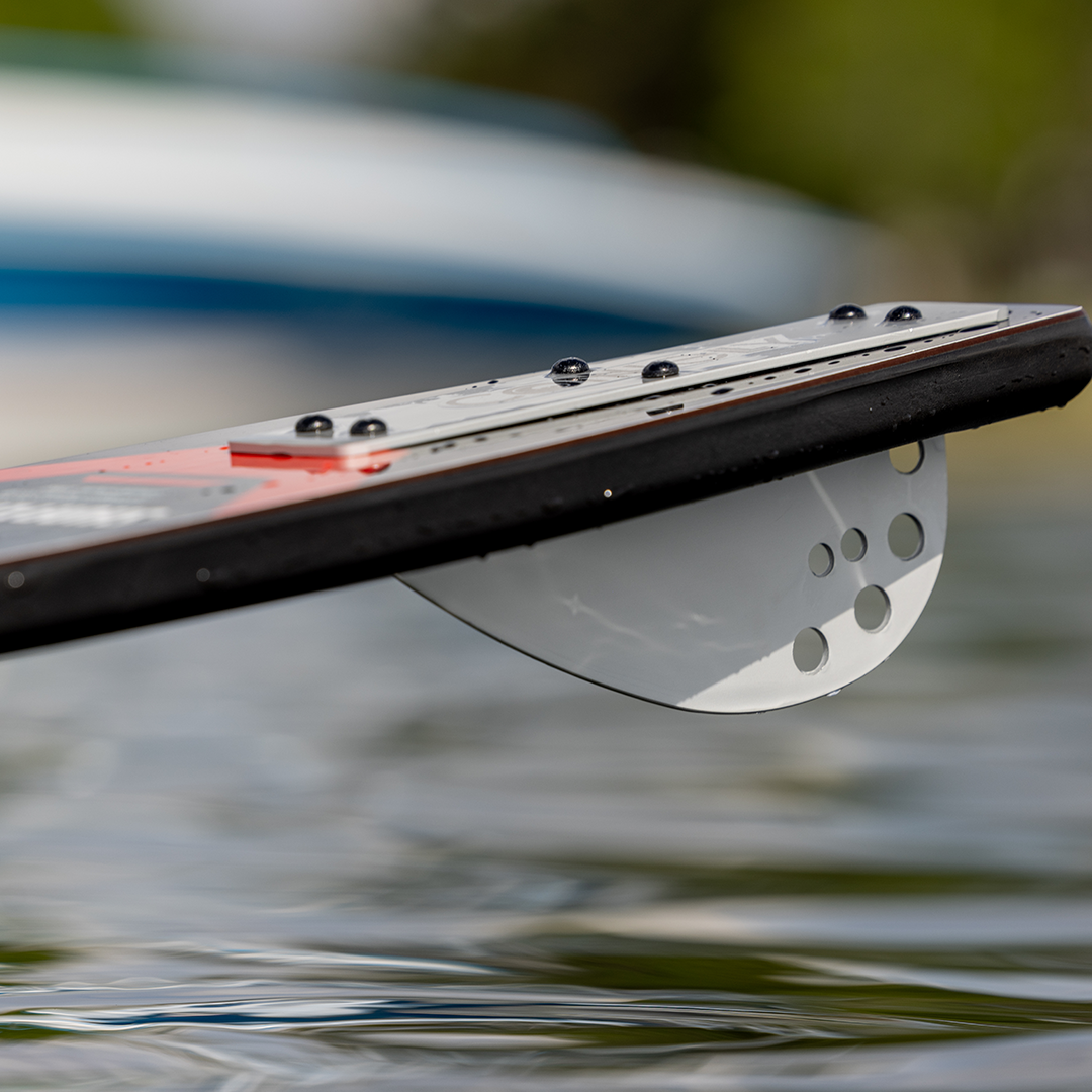 Close-up of the Shortline ski fin, a white perforated aluminum fin, with water droplets on the surface.