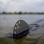Close-up of the Aspect water ski fin with perforated design, partially submerged in water.