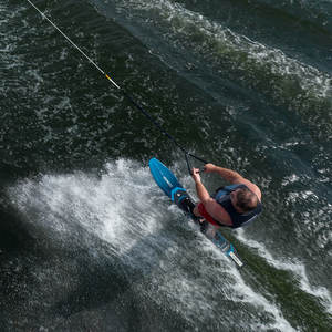 A skier carves through the water on a Connelly Big Daddy slalom ski, showcasing its control and stability.