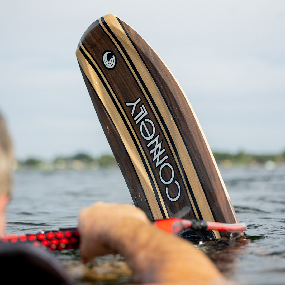 Close-up of the Connelly Big Easy ski partially submerged in water, displaying its elegant woodgrain finish.