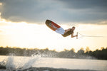 Action shot of a wakeboarder performing an aerial trick on the PURE wakeboard at sunset.