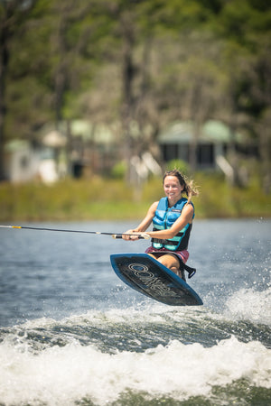 Rider in mid-air while kneeboarding on the Boost, gripping the handle and maintaining balance over the water’s wake.