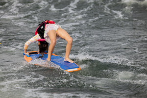 Wakeboarder bending back effortlessly, touching board on waves—Wild Thing style.