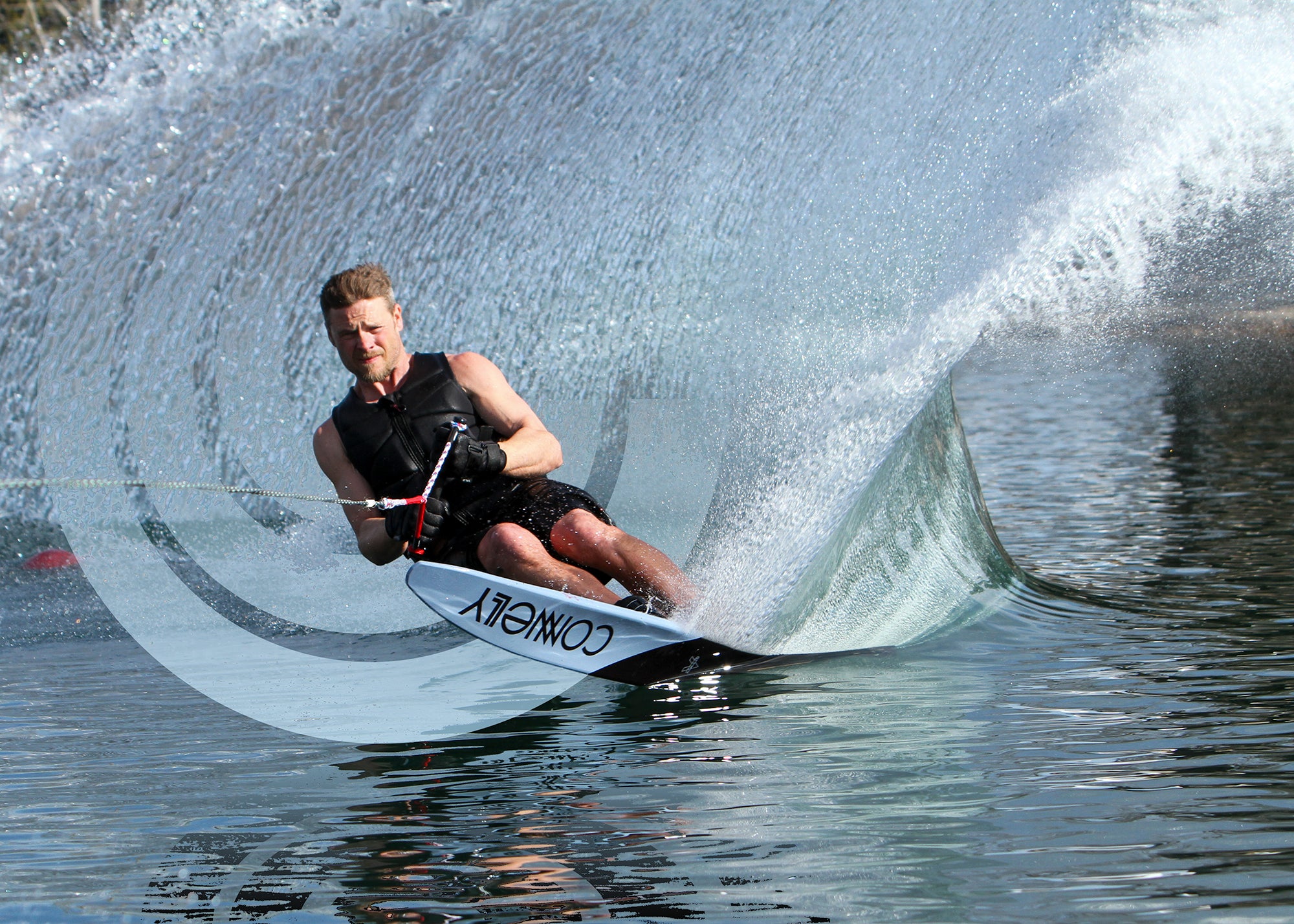Water skier making a turn throwing up water making a turn with an overlayed Connelly logo.