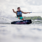 Wakeboarder carving on the Connelly 2024 Standard, creating a spray of water while riding with a relaxed stance.