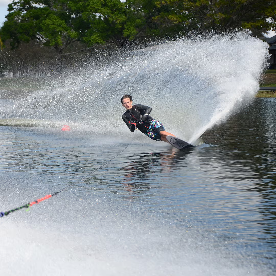 Person water skiing with a spray of water in the background.