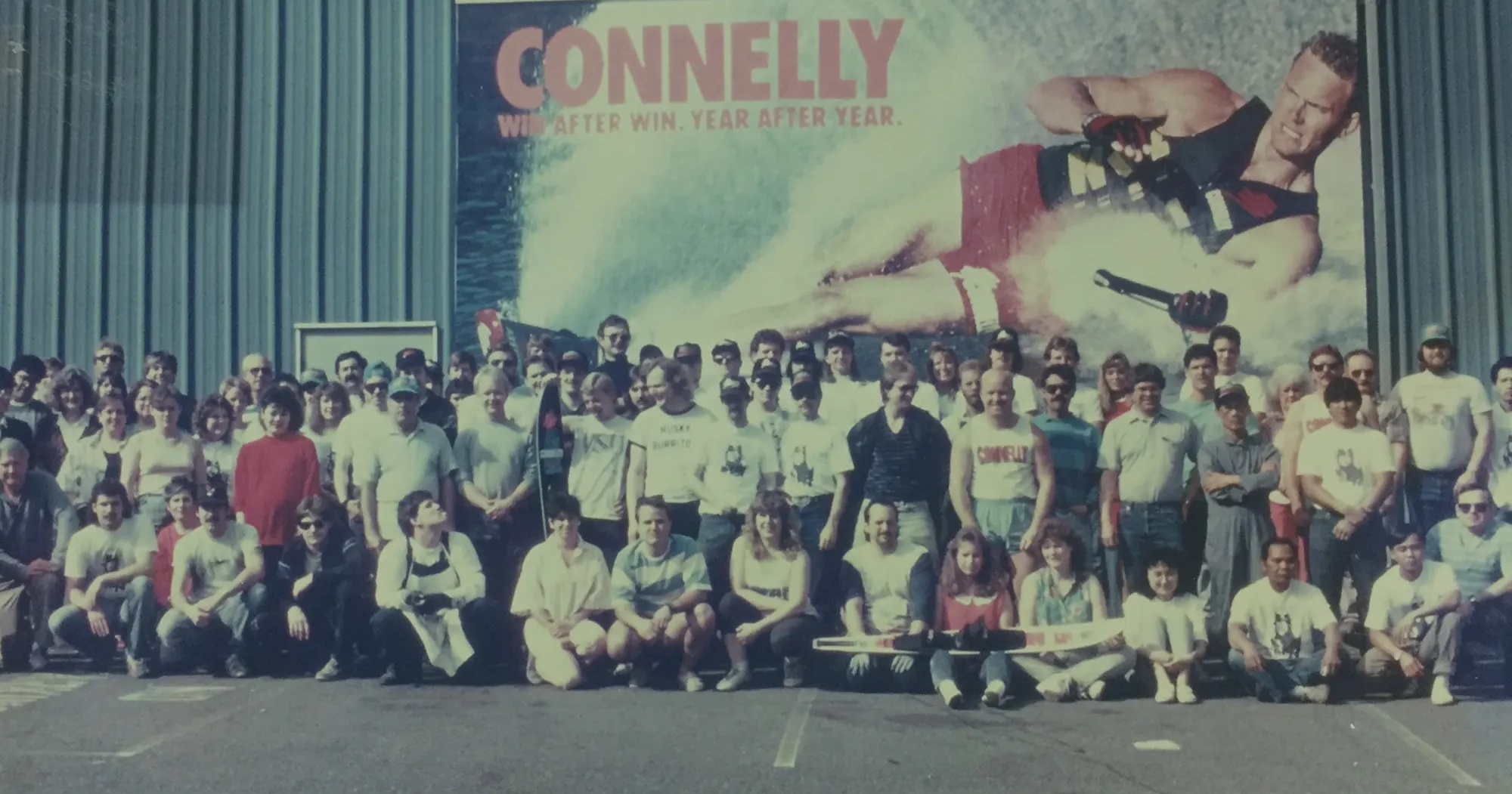 Vintage photo of the Connelly Skis team standing in front of a branded banner, celebrating the brand’s rich legacy.