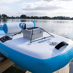 Battery box setup on a paddleboard, featuring a white waterproof case secured with bungee cords near the water.