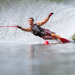 A skier carving through the water on a 2021 DV8 waterski, creating a spray while demonstrating high-speed agility.