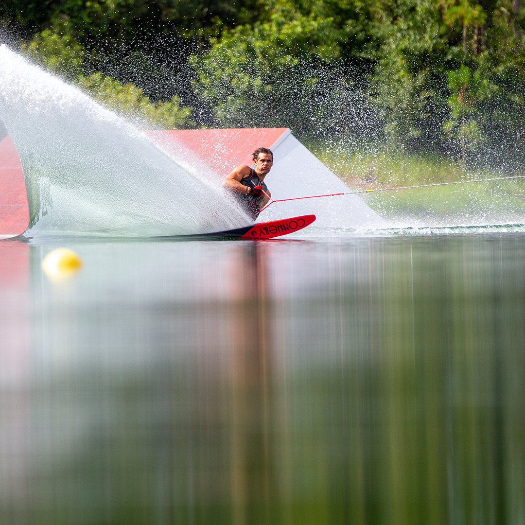 A waterskier leaning into a sharp turn on the 2021 DV8 waterski, showcasing precision control and dynamic movement.