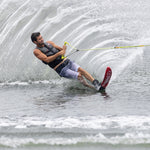 Skiing on a lake with mounted 2022 Outlaw skis, creating a large splash behind them.