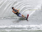 Skiing on a lake with mounted 2022 Outlaw skis, creating a large splash behind them.