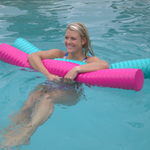 Woman in a blue swimsuit floating in a pool using pink and mint Deluxe Party Noodles with a textured, ridged design.