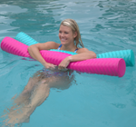 Woman in a blue swimsuit floating in a pool using pink and mint Deluxe Party Noodles with a textured, ridged design.
